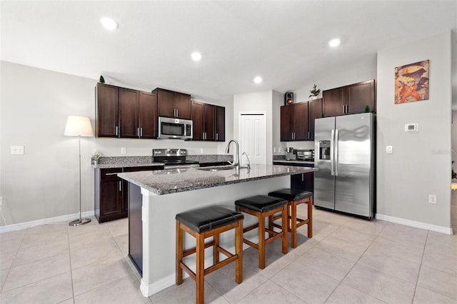 16632 Sunburst Lake St, Wimauma, FL 33598 - kitchen with stainless steel appliances, a sink, a breakfast bar area, baseboards, and recessed lighting