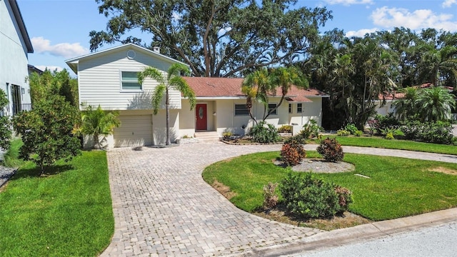 1238 Monterey Blvd NE, Saint Petersburg, FL 33704 - split level home with decorative driveway, a front lawn, and an attached garage