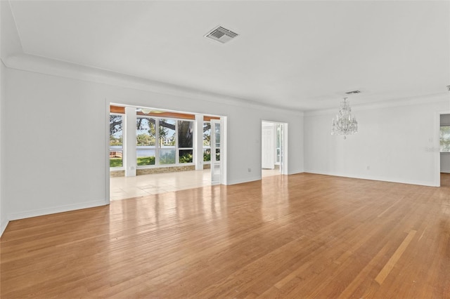 1238 Monterey Blvd NE, Saint Petersburg, FL 33704 - unfurnished living room with a chandelier, healthy amount of natural light, and light wood-type flooring