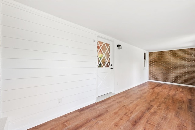 509 Falmouth St, Temple Terrace, FL 33617 - spare room with brick wall, baseboards, and wood finished floors
