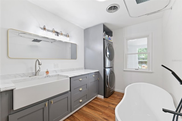 509 Falmouth St, Temple Terrace, FL 33617 - laundry area featuring stacked washer / drying machine, dark wood-type flooring, and baseboards