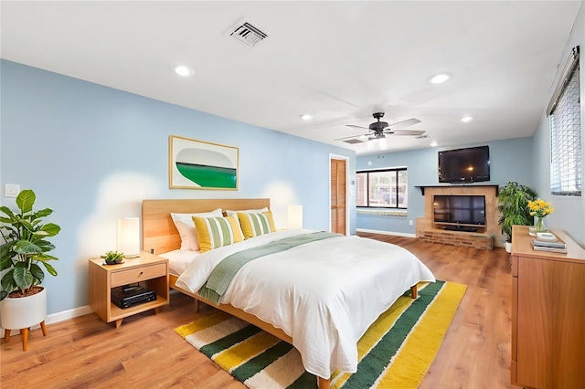 509 Falmouth St, Temple Terrace, FL 33617 - bedroom with light wood-style floors, baseboards, recessed lighting, a fireplace, and a ceiling fan