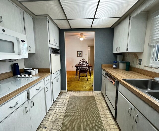 2195 Academy Dr, Clearwater, FL 33764 - kitchen with white appliances, light flooring, a ceiling fan, and light countertops