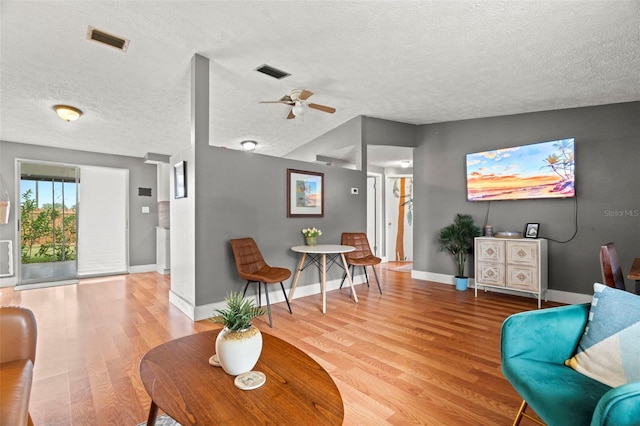 4150 Pecos Dr, New Port Richey, FL 34653 - living room with wood finished floors, a textured ceiling, a ceiling fan, and baseboards