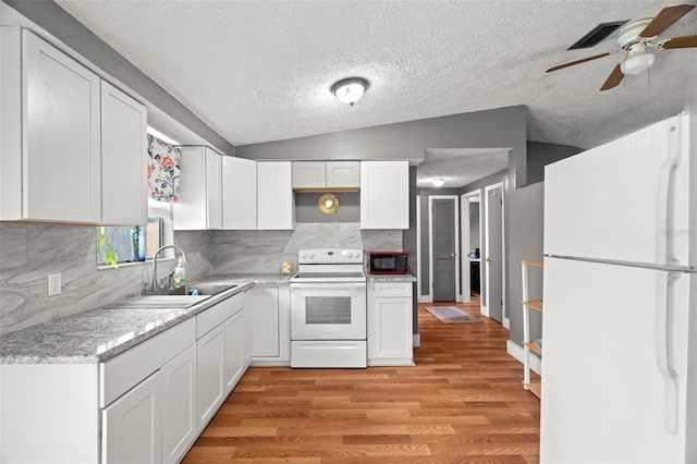 4150 Pecos Dr, New Port Richey, FL 34653 - kitchen featuring white appliances, a sink, a ceiling fan, light wood-type flooring, and white cabinets