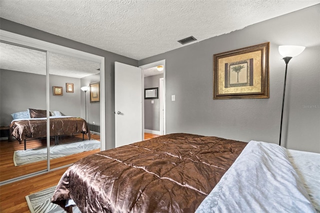 4150 Pecos Dr, New Port Richey, FL 34653 - bedroom with wood finished floors, a textured ceiling, and a closet