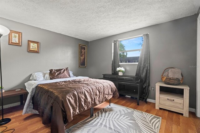 4150 Pecos Dr, New Port Richey, FL 34653 - bedroom with wood finished floors and a textured ceiling