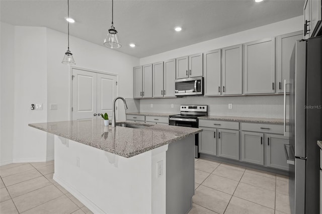 12697 Achasta Blvd, Hudson, FL 34669 - kitchen with stainless steel appliances, a sink, light tile patterned flooring, a kitchen island with sink, and recessed lighting