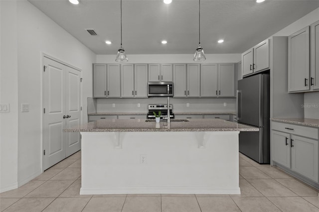 12697 Achasta Blvd, Hudson, FL 34669 - kitchen featuring appliances with stainless steel finishes, a sink, recessed lighting, light tile patterned floors, and a kitchen island with sink