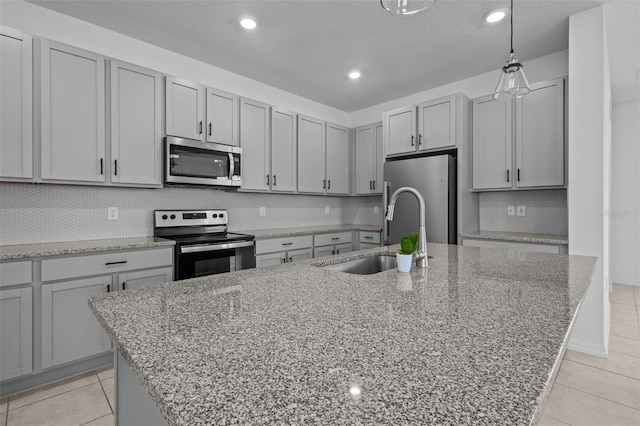 12697 Achasta Blvd, Hudson, FL 34669 - kitchen with stainless steel appliances, a sink, a center island with sink, light stone counters, and recessed lighting
