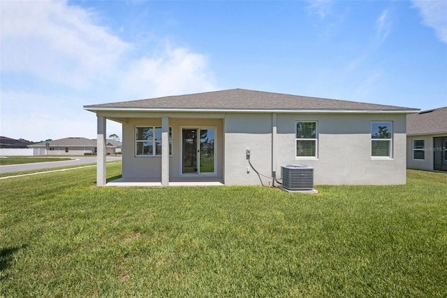 12697 Achasta Blvd, Hudson, FL 34669 - rear view of property with cooling unit, stucco siding, and a lawn
