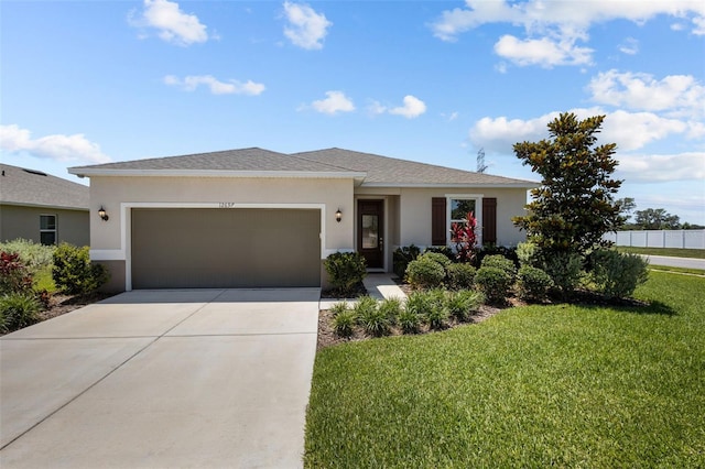 12697 Achasta Blvd, Hudson, FL 34669 - view of front of house with stucco siding, an attached garage, a front yard, driveway, and roof with shingles
