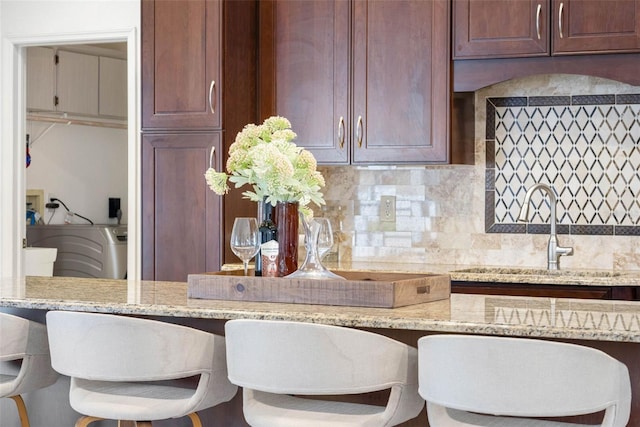 12470 93rd St, Largo, FL 33773 - kitchen with backsplash, a sink, and light stone countertops