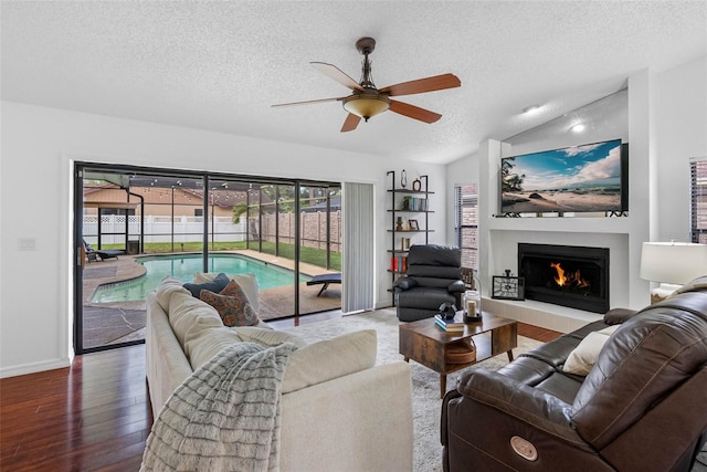 12470 93rd St, Largo, FL 33773 - living area featuring a ceiling fan, a textured ceiling, vaulted ceiling, wood finished floors, and a tiled fireplace