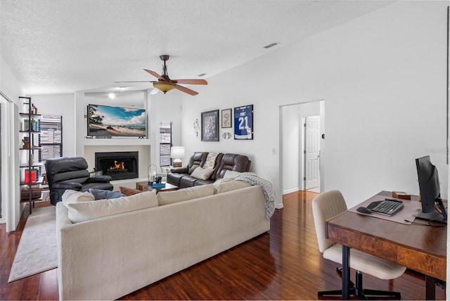 12470 93rd St, Largo, FL 33773 - living area featuring wood finished floors, a textured ceiling, a lit fireplace, a ceiling fan, and baseboards