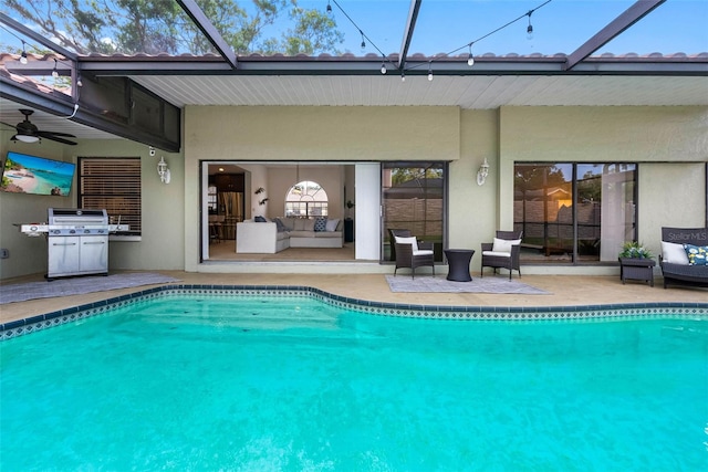 12470 93rd St, Largo, FL 33773 - outdoor pool featuring outdoor lounge area, a patio area, a ceiling fan, and glass enclosure