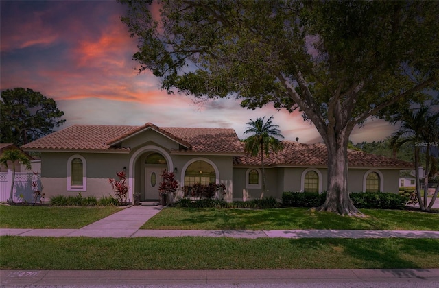 12470 93rd St, Largo, FL 33773 - mediterranean / spanish home with stucco siding, a yard, and a tile roof