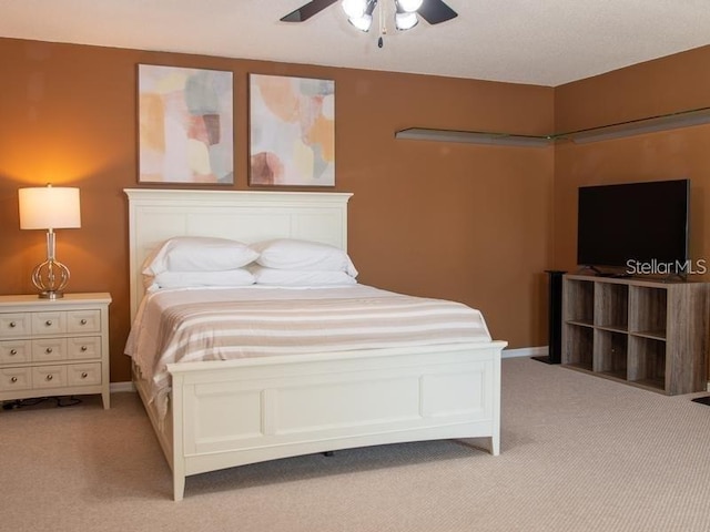101 8th St, Belleair Beach, FL 33786 - bedroom with light carpet, ceiling fan, and baseboards