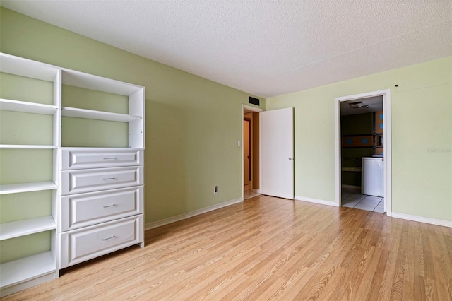 1799 N Highland Ave Unit 3, Clearwater, FL 33755 - unfurnished bedroom featuring light wood-style floors, baseboards, a textured ceiling, and ensuite bathroom