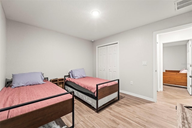 8009 N Primrose Dr, Citrus Springs, FL 34434 - bedroom with light wood-style floors, baseboards, and a closet