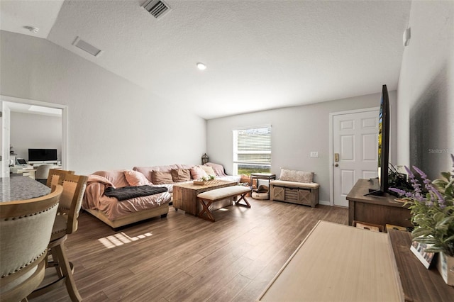8009 N Primrose Dr, Citrus Springs, FL 34434 - living area featuring lofted ceiling, wood finished floors, and a textured ceiling