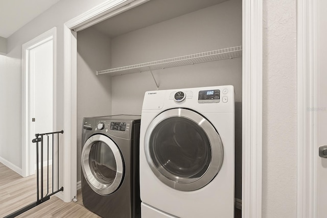 8009 N Primrose Dr, Citrus Springs, FL 34434 - laundry room featuring light wood-type flooring, washer and clothes dryer, and baseboards