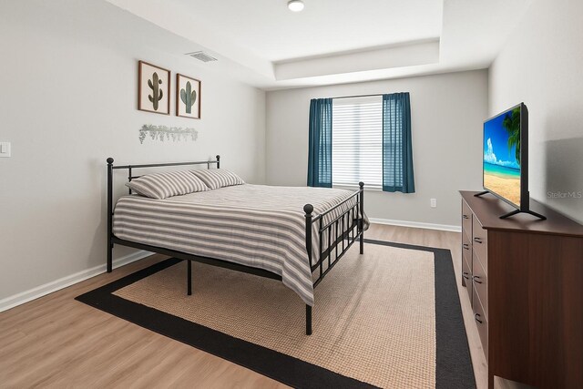 7839 N Quibble Ave, Citrus Springs, FL 34434 - bedroom featuring a tray ceiling, wood finished floors, and baseboards