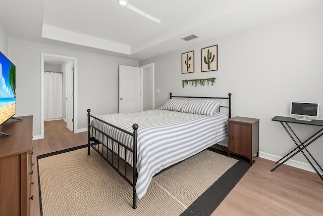 7839 N Quibble Ave, Citrus Springs, FL 34434 - bedroom with wood finished floors, a tray ceiling, and baseboards