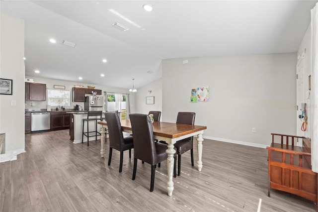 7839 N Quibble Ave, Citrus Springs, FL 34434 - dining area featuring light wood-style floors, vaulted ceiling, recessed lighting, and baseboards