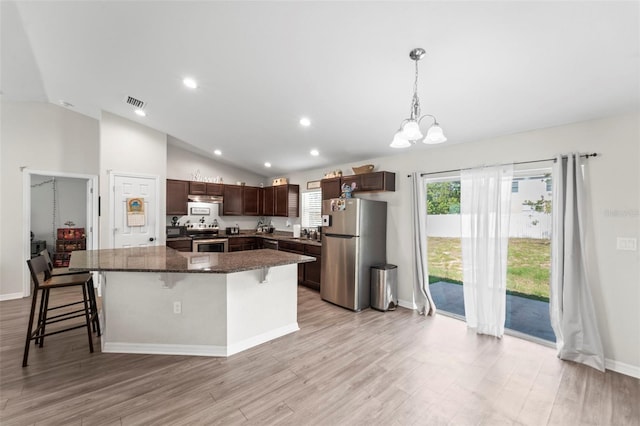7839 N Quibble Ave, Citrus Springs, FL 34434 - kitchen with stainless steel appliances, lofted ceiling, a chandelier, light wood-type flooring, and a breakfast bar area