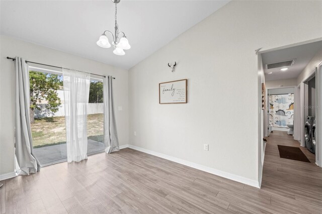 7839 N Quibble Ave, Citrus Springs, FL 34434 - unfurnished room with a chandelier, vaulted ceiling, light wood-type flooring, and baseboards