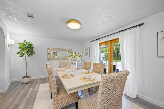 2900 Sandpiper Pl, Clearwater, FL 33762 - dining space featuring light wood-style floors, baseboards, and a textured ceiling