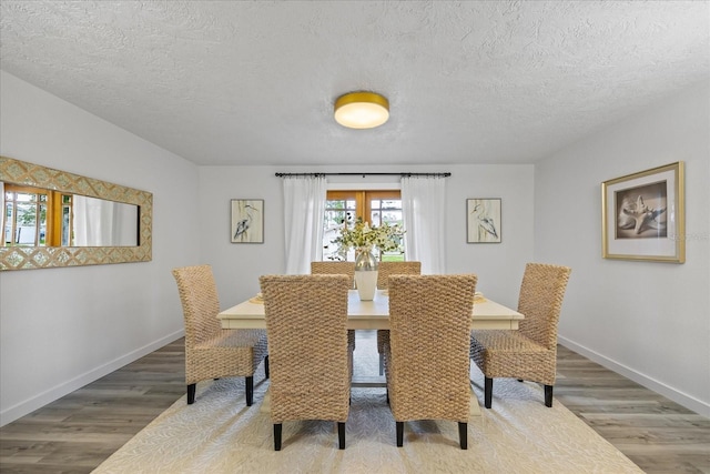 2900 Sandpiper Pl, Clearwater, FL 33762 - dining room featuring wood finished floors, baseboards, and a textured ceiling
