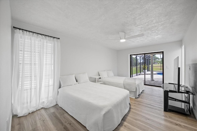 2900 Sandpiper Pl, Clearwater, FL 33762 - bedroom with access to exterior, light wood finished floors, a textured ceiling, and ceiling fan