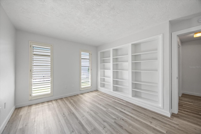 2900 Sandpiper Pl, Clearwater, FL 33762 - unfurnished room featuring wood finished floors, baseboards, a textured ceiling, and built in features