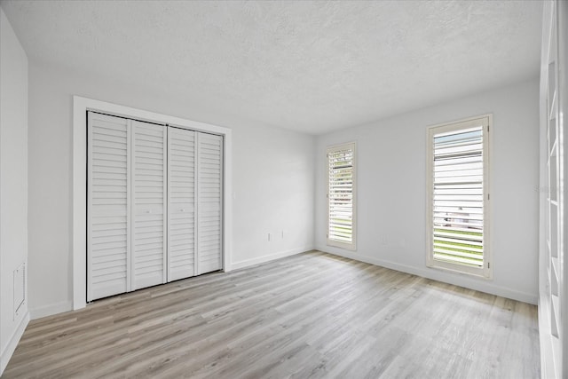 2900 Sandpiper Pl, Clearwater, FL 33762 - unfurnished bedroom with wood finished floors, a textured ceiling, baseboards, and a closet