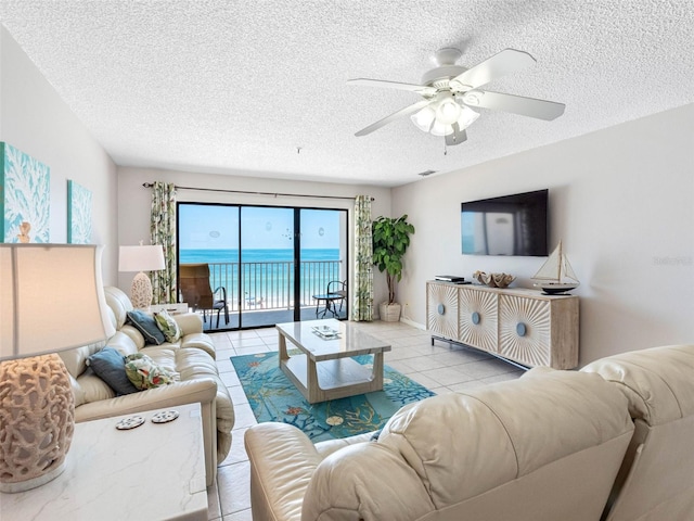 13500 Gulf Blvd Unit 506, Madeira Beach, FL 33708 - living room with a textured ceiling, a ceiling fan, tile patterned flooring, and baseboards