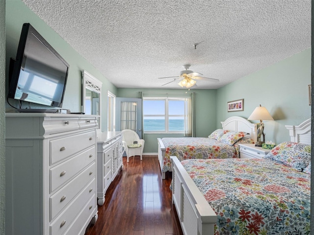 13500 Gulf Blvd Unit 506, Madeira Beach, FL 33708 - bedroom with dark wood finished floors, a textured ceiling, and a ceiling fan