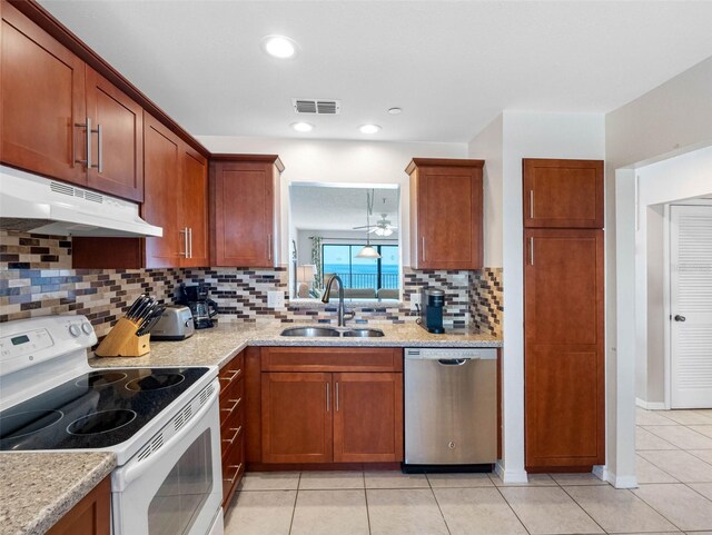 13500 Gulf Blvd Unit 506, Madeira Beach, FL 33708 - kitchen with dishwasher, white electric range oven, a sink, under cabinet range hood, and light tile patterned flooring
