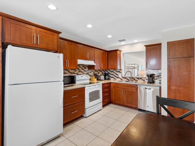 13500 Gulf Blvd Unit 506, Madeira Beach, FL 33708 - kitchen with stainless steel appliances, under cabinet range hood, decorative backsplash, a sink, and light countertops