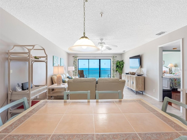 13500 Gulf Blvd Unit 506, Madeira Beach, FL 33708 - tiled dining room featuring ceiling fan and a textured ceiling
