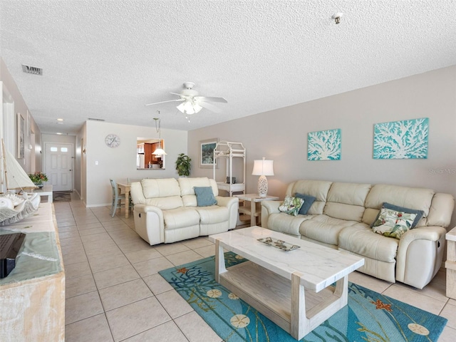 13500 Gulf Blvd Unit 506, Madeira Beach, FL 33708 - living area featuring light tile patterned floors, a ceiling fan, and a textured ceiling