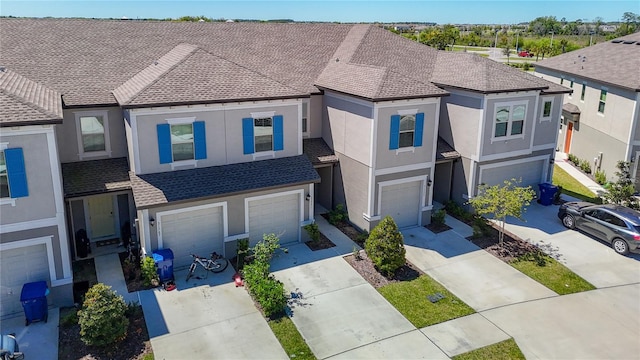 31771 Blue Passing Loop, Wesley Chapel, FL 33545 - view of front of house with concrete driveway, an attached garage, stucco siding, and roof with shingles