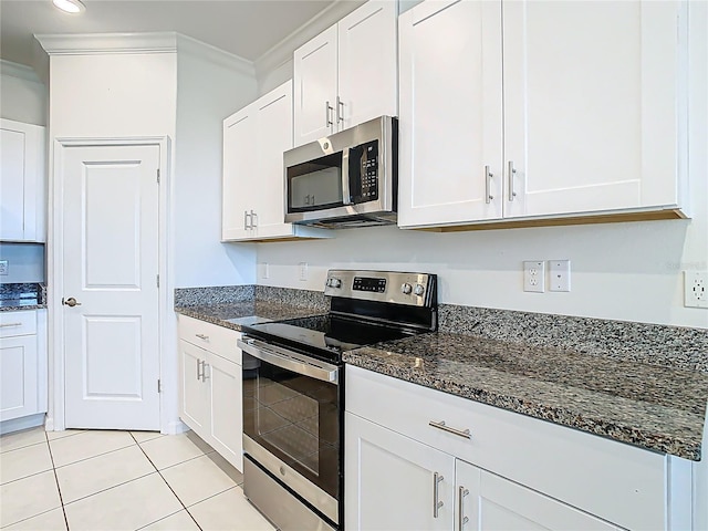31771 Blue Passing Loop, Wesley Chapel, FL 33545 - kitchen featuring appliances with stainless steel finishes, ornamental molding, white cabinetry, dark stone countertops, and light tile patterned floors