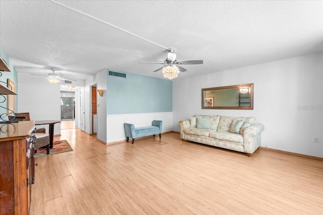 2630 Pearce Dr Unit 108, Clearwater, FL 33764 - living room with ceiling fan, light wood-style flooring, a textured ceiling, and baseboards