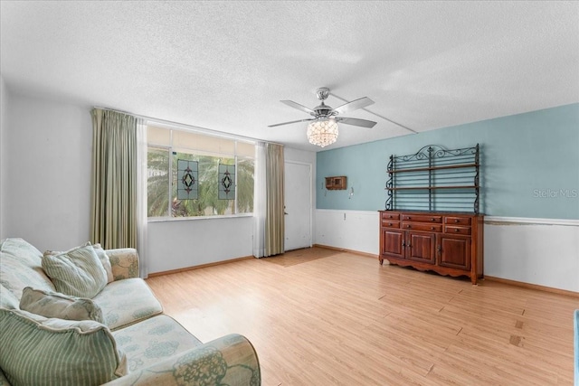 2630 Pearce Dr Unit 108, Clearwater, FL 33764 - living area with light wood finished floors, a textured ceiling, ceiling fan, and wainscoting