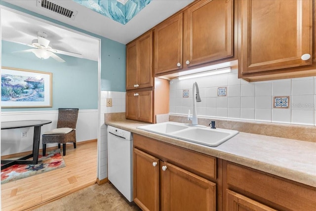 2630 Pearce Dr Unit 108, Clearwater, FL 33764 - kitchen with dishwasher, a sink, brown cabinets, light countertops, and decorative backsplash