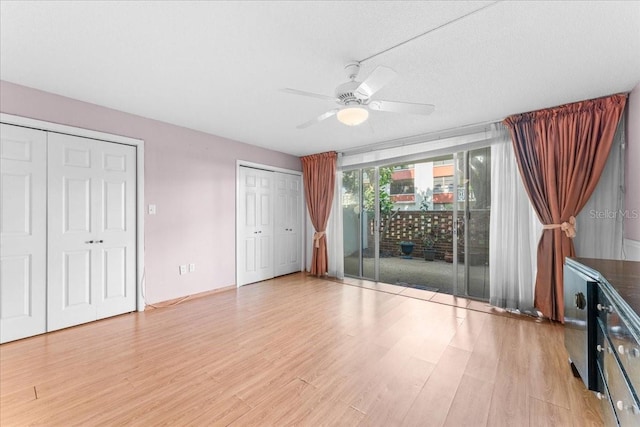 2630 Pearce Dr Unit 108, Clearwater, FL 33764 - unfurnished bedroom with access to outside, light wood-type flooring, multiple closets, and a ceiling fan