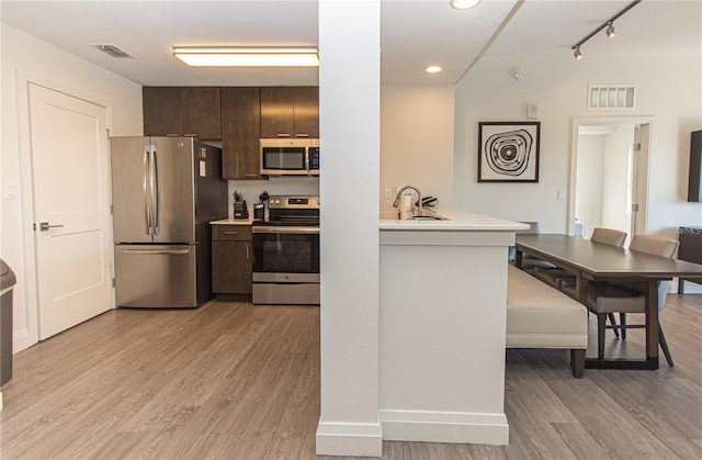 14501 Grove Resort Ave Unit 3316, Winter Garden, FL 34787 - kitchen with appliances with stainless steel finishes, light wood finished floors, light countertops, dark brown cabinets, and a sink