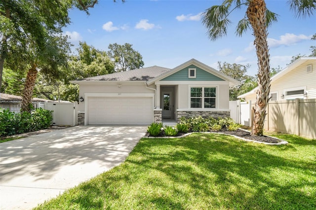 527 Bay St, Dunedin, FL 34698 - view of front of house featuring stone siding, an attached garage, driveway, stucco siding, and a gate